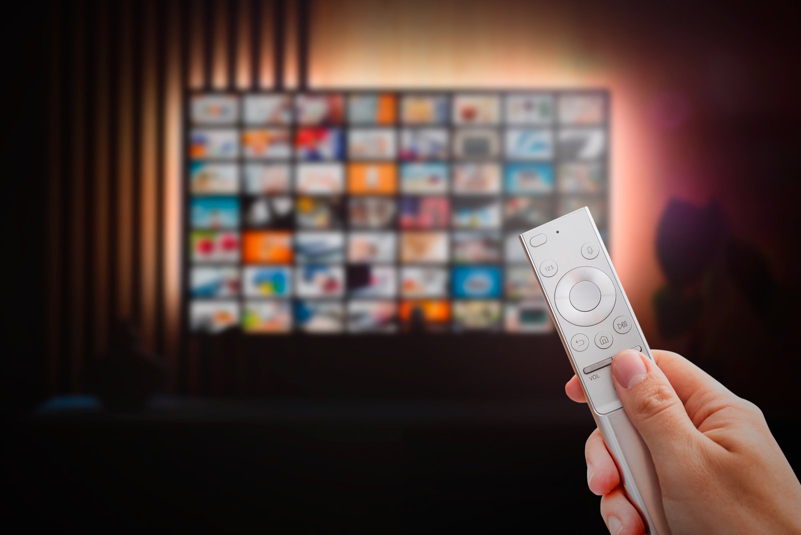 Man Watching TV with Remote Control in Hand.